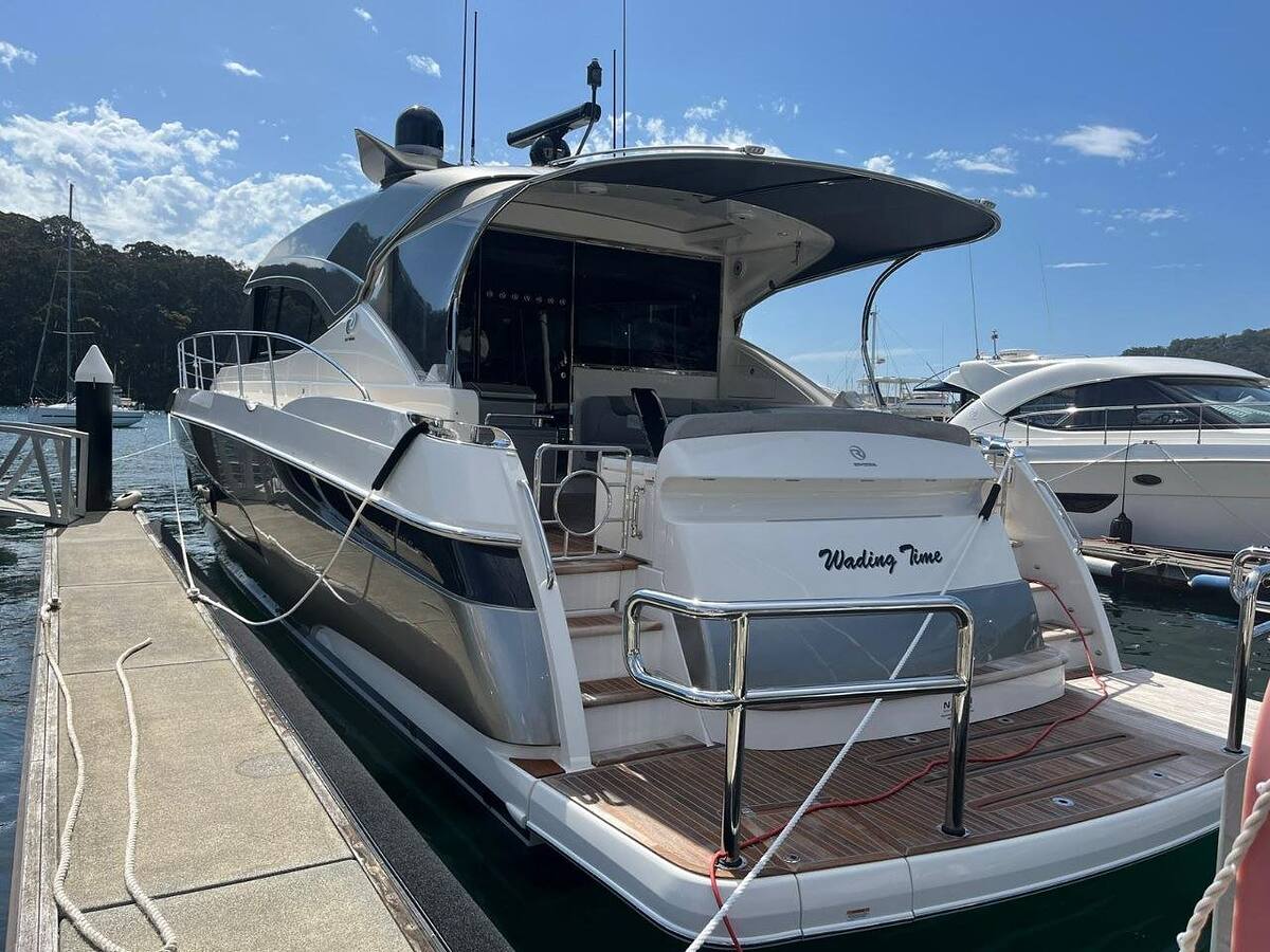 Freshly detailed motor yacht with a teak swim platform berthed at a marina